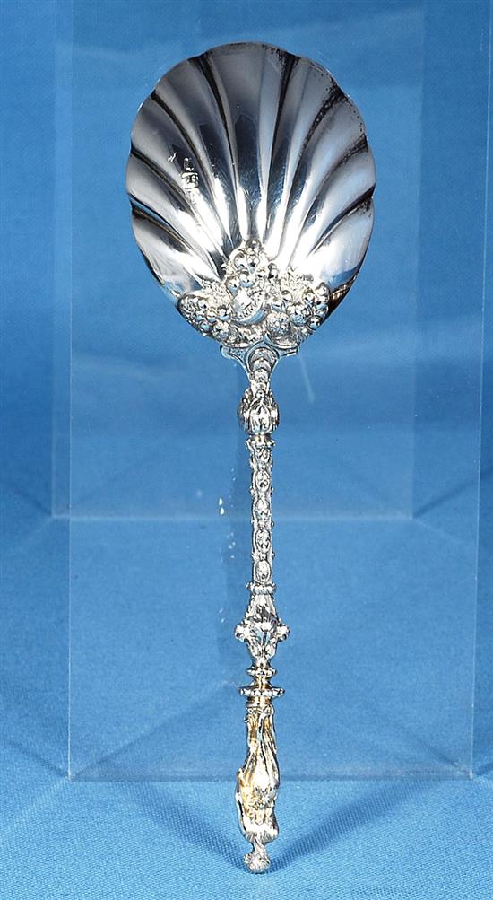 A cased set of four Victorian silver parcel gilt fruit serving spoons and a sugar sifter, spoon 197mm, weight 12.4oz/388 grms.